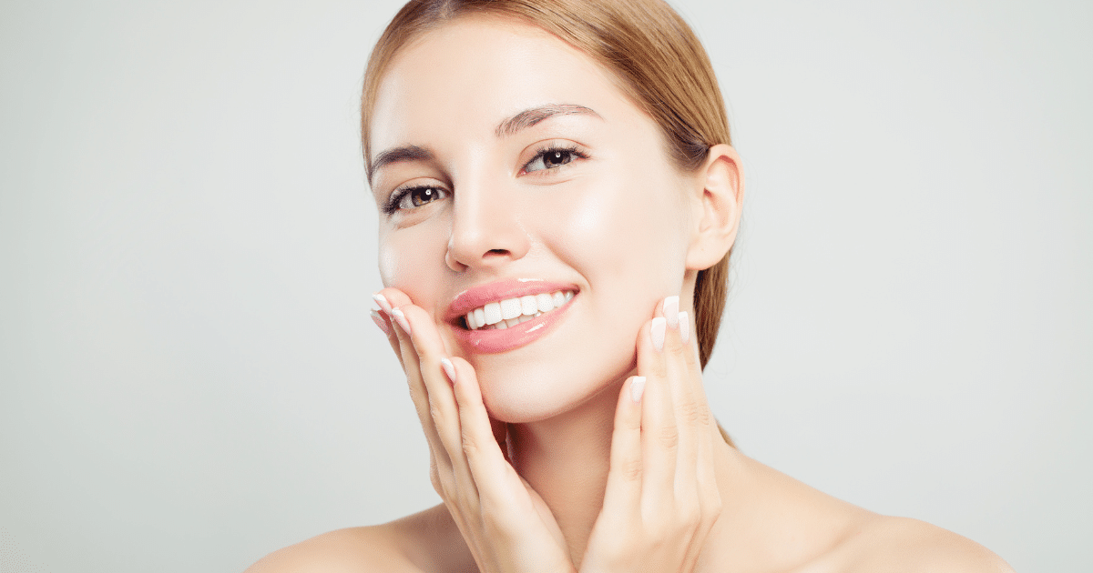 a lovely woman with blonde hair touching her lovely face with her two hands