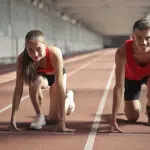 A man and a woman preparing into running posture